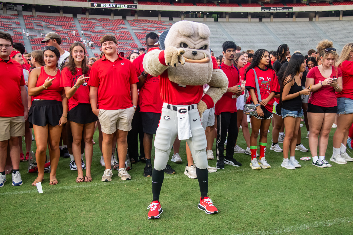 Hairy Dawg poses in front of students from the UGA Class of 2030 on Dooley Field.