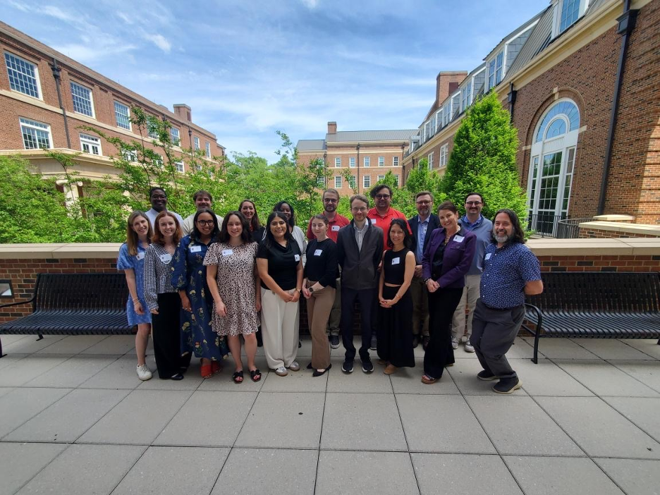 A group of new employees smiling on a patio at the Terry College of Business