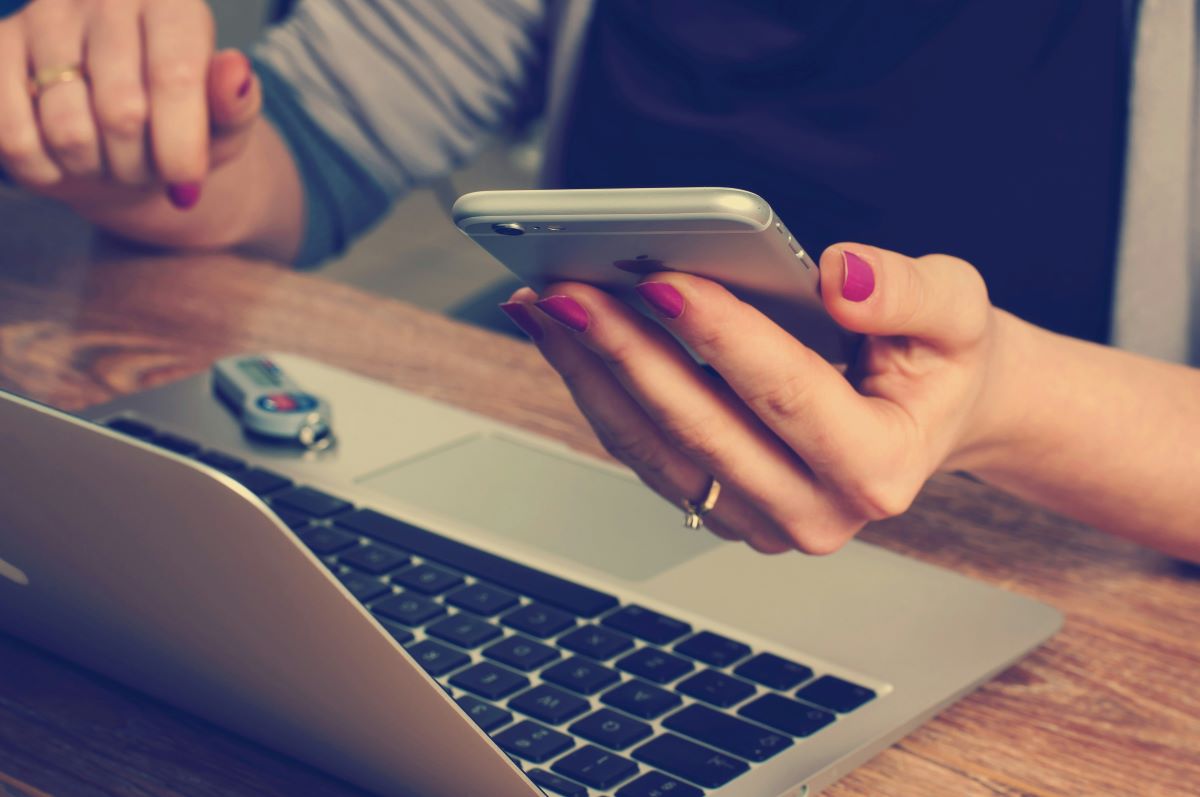 Phone in hand by computer